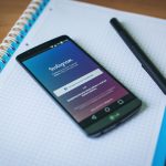 Instagram on a smartphone with a notebook