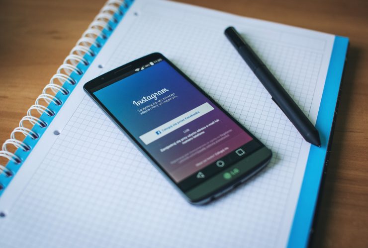 Instagram on a smartphone with a notebook