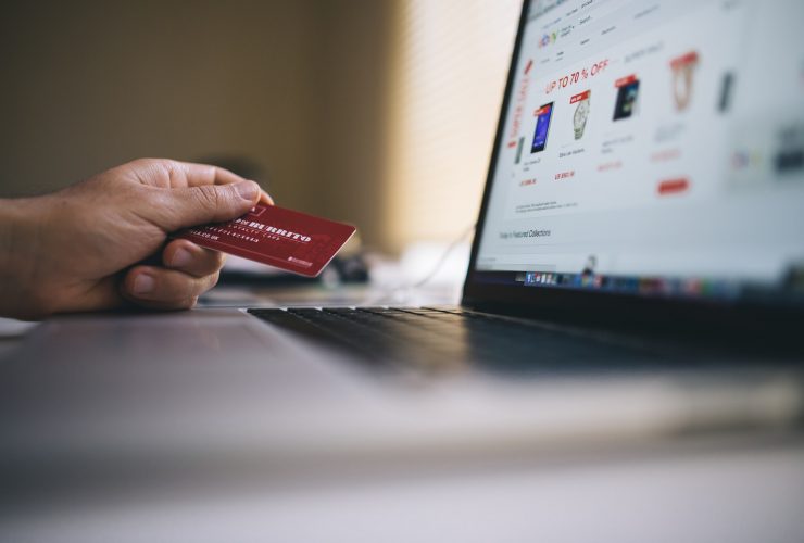 a person using a credit card to buy on a laptop